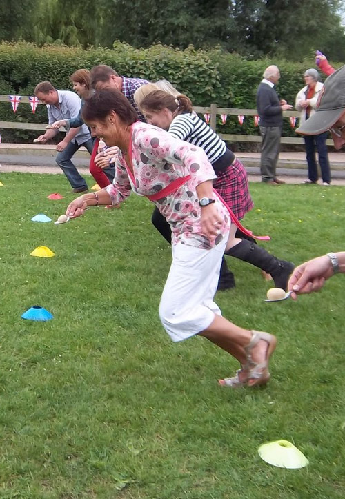 4 people having an egg race at a sports day  